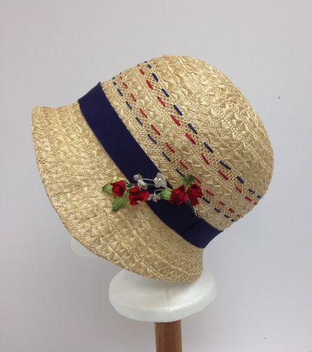 Red and blue embroidery threads were woven in to the straw.  The band was made from blue petersham ribbon.  Small flowers trim the left side.
