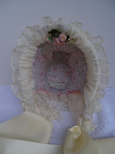 In side view of the pink bonnet shows off the calico lining, not historically accurate, but very pretty.
