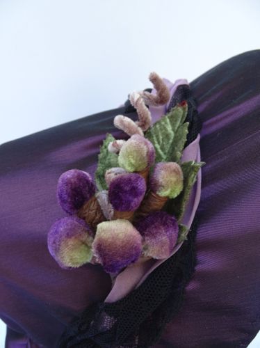 The outside of the bonnet is trim med with a cluster of velvet grapes that includes a grape tendril and some leaves for contrast.