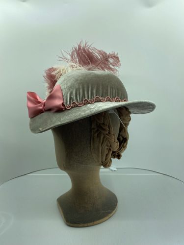 The front of the hat has a pink satin bow, just off centre.