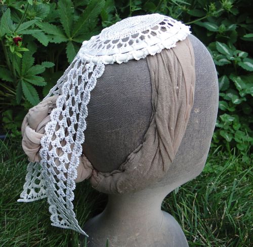 The velvet ribbon around the perimeter adds enough body to the lace to keep it in a slightly domed shape.