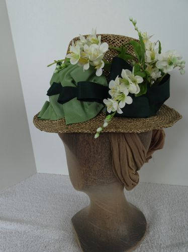 The masculine flowerpot shape is countered by an abundance of flowers to feminize the hat.