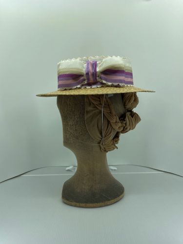Made in 2021 this blocked straw boater is trimmed with a mauve striped picot ribbon.