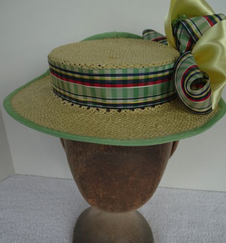 The outer edge is wired and bound with green petersham ribbon, and the green plaid ribbon forms the band.