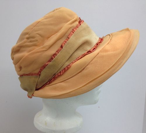 An original 1920's fabric hat was re-decorated with velvet ribbon and pink silk fabric to spruce it up. This one has the "poke" brim of the 1920's.