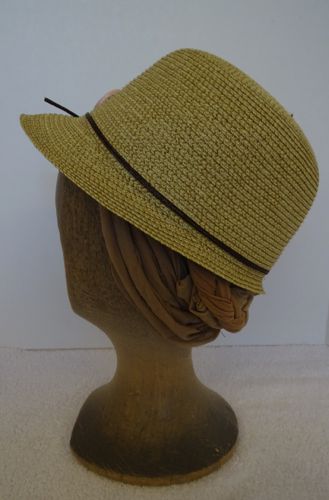 The hat band is made of a single narrow strand of straw in brown.  Narrow bands like these were quite stylish in 1931, the year of the story of this show.
