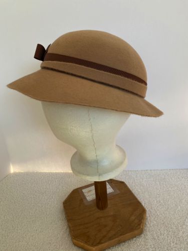 Asymmetry was common throughout the 1930's, and this hat has an asymmetrical decorative felt band over a brown petersham ribbon.