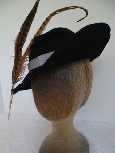 The two Pheasant tail feathers seem to sit on the edge of the brim, defying gravity, but they are attached with a small strip of felt.