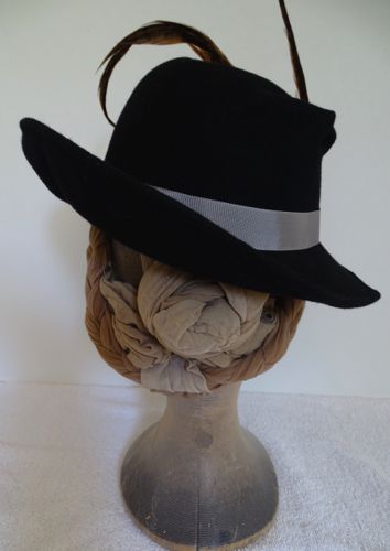 One side of the brim was tilted sharply to balance the opposite side with the feathers.