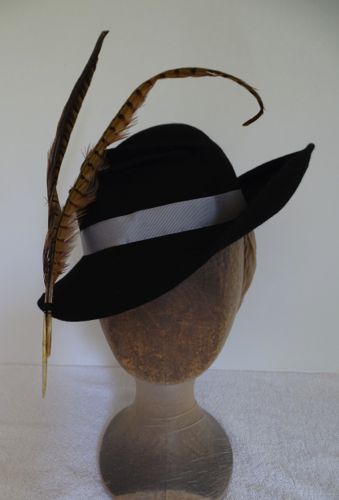 Originally made for a theatre production, this black felt hat is decorated with two long pheasant tail feathers and a pale grey petersham hat band.