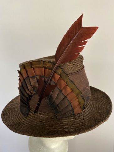 Three different wired and pleated ribbons form the half-circle of trim.  A Turkey feather was dyed to match and cut into an arrow shape.
