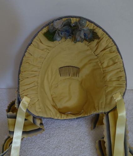 The lining is a warm yellow cotton fabric; very comfortable and cool to wear.  There's a comb and some satin ribbon ties to keep the bonnet in place.