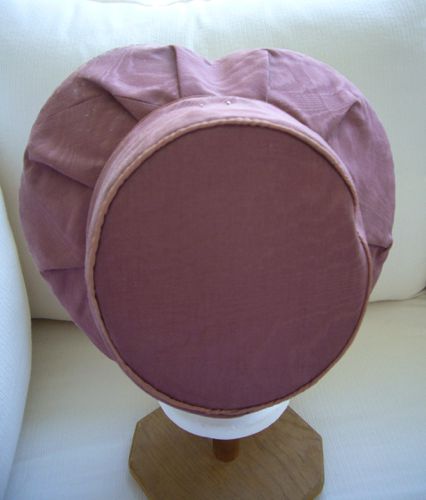 The brim and tip are both piped with satin.