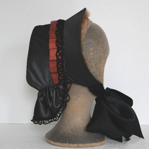 Buckram frame is covered with slate grey taffeta and trimmed with black gimp and rust duppioni silk pleated frill.