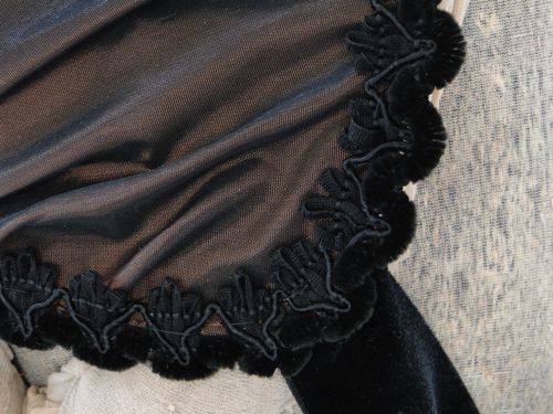 Trim is black chenille and rayon gimp, strings are of black silk velvet.