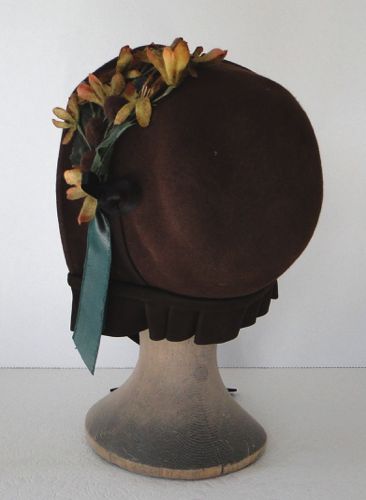 The back has a tiny curtain of pleated brown satin, which matches the small ties in the front.