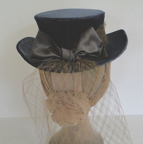 The back of this covered-buckram topper is completed with a taffeta ribbon bow.