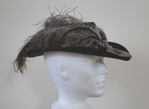 Natural ostrich feathers and brown goose biots trim this riding hat style.