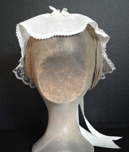 This ivory day cap is from 1860-1863 and is trimmed with narrow cotton lace.