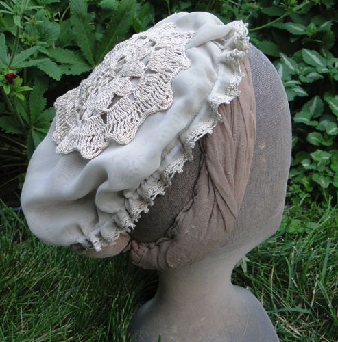 The Mob-Cap style day cap is made of beige georgette and trimmed with beige cotton crochet lace.