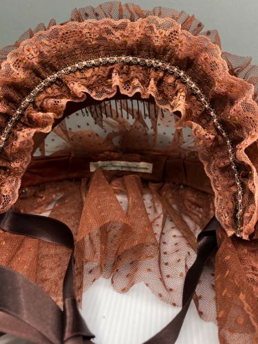 The inside of the headdress has been fitted with a wire hair comb to keep it properly in place.