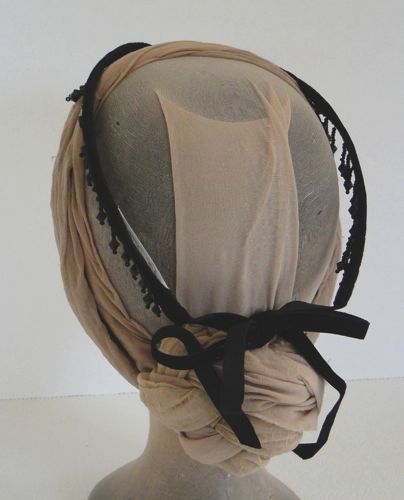 This diadem is made from black velvet ribbon sewn over millinery wire and trimmed with beaded fringe.  Ribbon ties make this a size-adjustable headdress.