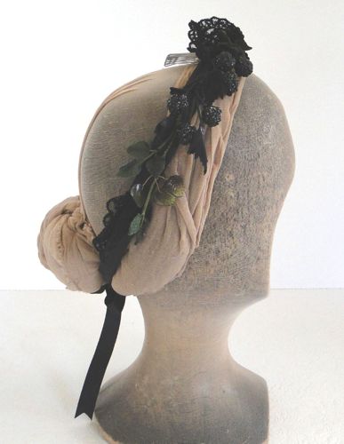 There are also some green glass and fabric leaves twined into the headdress. The right side has more decorations.