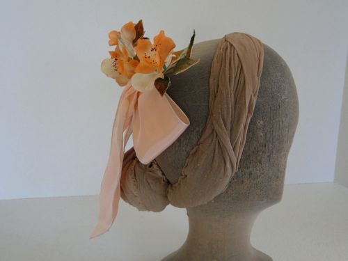 Apricot coloured flowers and rose leaves decorate the bow.