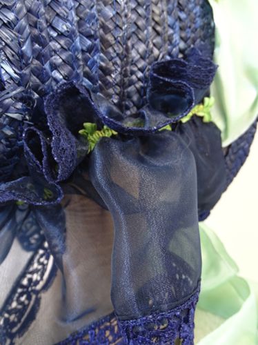 Another view of the curtain trimmed with blue lace and green braid.