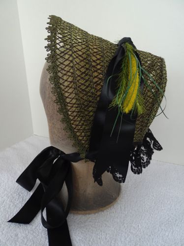 This lacy straw bonnet was made from a synthetic straw that was originally a bright yellow sunhat!  The straw was over-dyed to this olive green color.