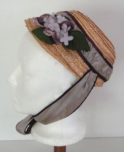 The outside is decorated with a hat band made from gathered silk duppioni edged with ribbon and some lilacs and green leaves.