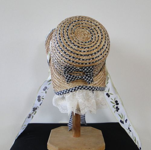 The bonnet has gingham bias in the crown, gingham bows, and a binding of bias on the brim; curtain is of lace.