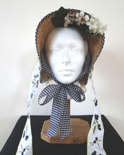 Braided straw Spoon bonnet made for “Hell On Wheels” 2012 trimmed with tiny white blossoms and small glass berries.