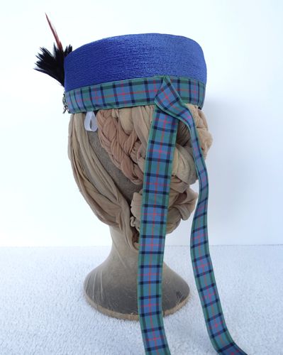 Two tails of the plaid ribbon form streamers at the back of the hat.