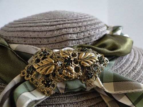 A filigree brooch decorates the back of the hat.