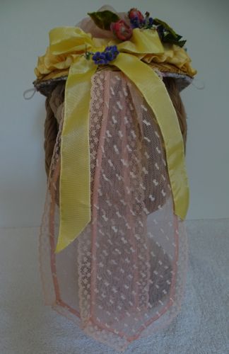 Streamers are made of flocked pink net covered with pink tulle and trimmed with narrow pink lace.  A wired yellow ribbon bow graces the top.