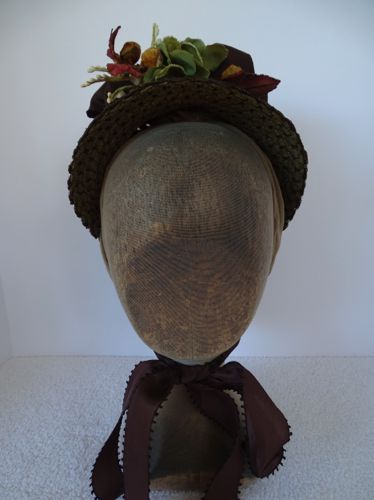 The front view of the hat shows the flowers peeking out at the top, and the ribbon ties at the chin.