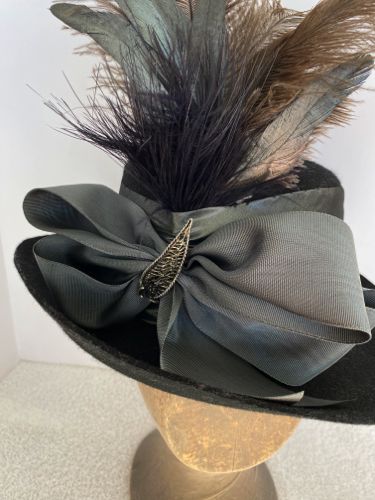 Detailed view of the moiré taffeta bow and metal trim at the front of the hat.