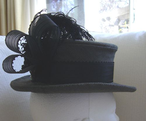 Band is of ribbed picot-edged taffeta ribbon, trimmed with loops of the same ribbon and curled black ostrich feathers.