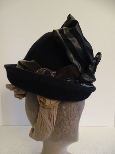 The turned up brim was wired and covered with black petersham ribbon.  Warm grey velvet ribbon and metal decorations form the hat band.
