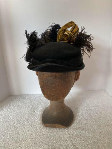 A re-purposed black felt hat with a satin facing was used for this 1893 feathered style.