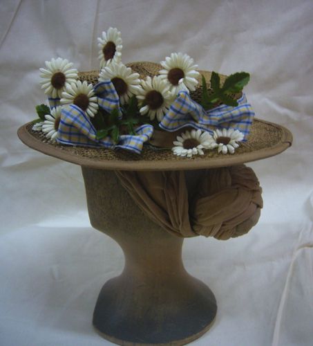 A large number of paper daisies and ribbon bows form the decoration on the left side.