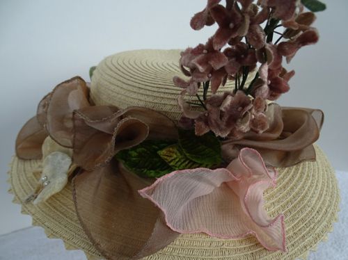 This hat has an almost completely hidden hat band made of pink silk dupioni that has been generously covered with chiffon puffs in pink and mocha.
