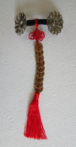 Clip-in hair decoration with brass, coins, tassel, and ribbon.