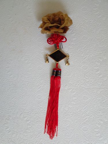 Clip-in hair decoration with one gold rose, cord knot, tassel, and brass bells.