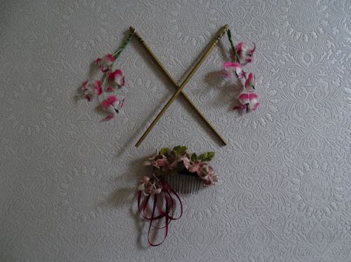 Two fast-food chopsticks were painted gold; small holes were drilled to accommodate swinging fuchsias.  A small arrangement of flowers and ribbon on a comb was also prepared.